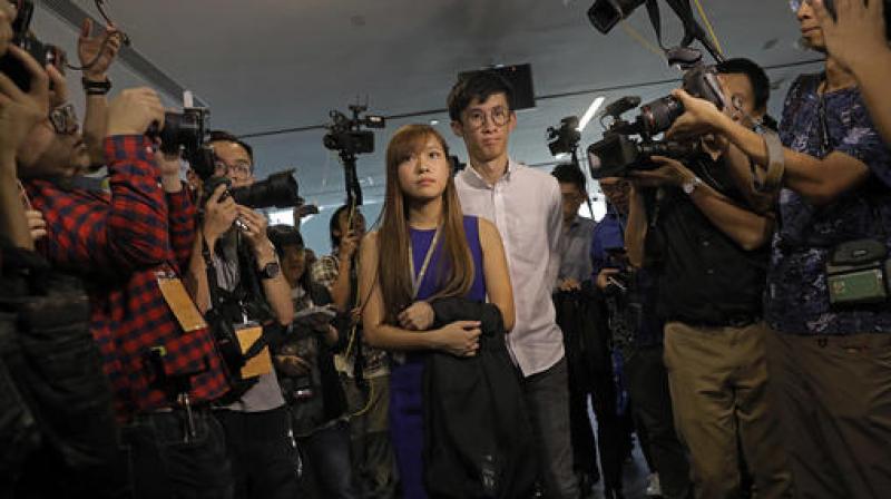 Hong Kong lawmakers Yau Wai-ching, center left, and Sixtus Leung, center right, are surrounded by photographers outside the legislature council in Hong Kong. (Photo: AP)