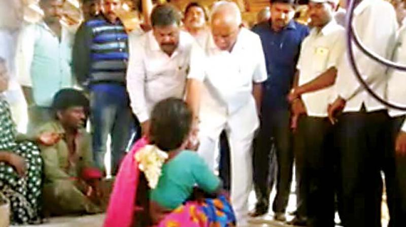 A TV grab shows B.S. Yeddyurappa giving Rs 1 lakh to the wife of a farmer who committed suicide in Gundlupet.