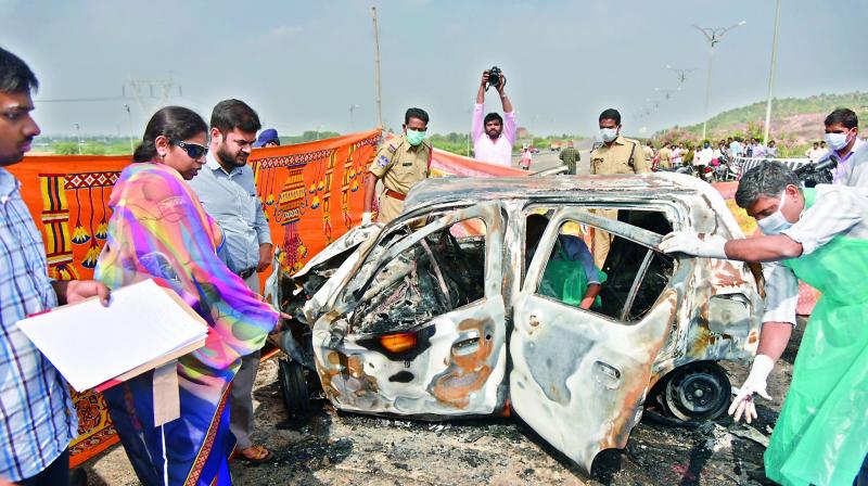 A forensic team examines the burnt car at the ORR on Monday.
