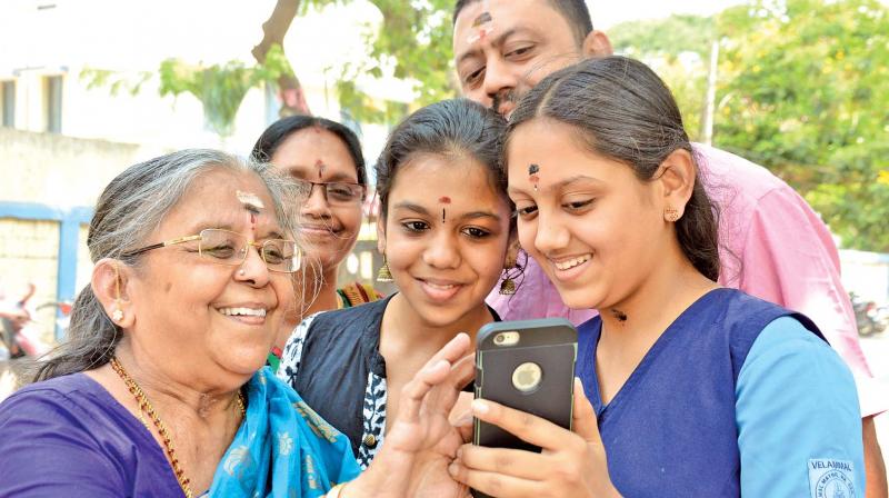 A student shows her results to her grandmother on her phone while the rest of the family looks on in Mogappair on Friday. (Photo: DC)