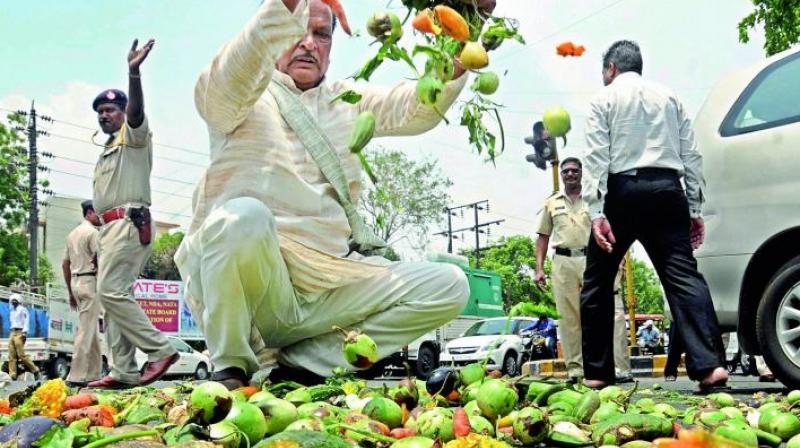 Farmers throwing vegetables on a road during a protest as part of the Maharashtra bandh over various demands in Nagpur, Maharashtra on Monday. (Photo: PTI)