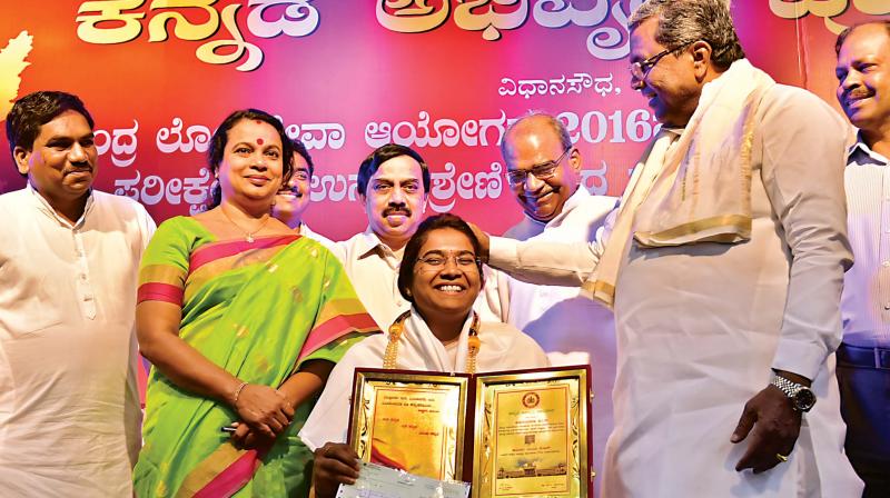 Chief Minister Siddaramaiah felicitates UPSC exam toppers from Karnataka at a programme at Gandhi Bhavan in the city on Wednesday. Minister Umashree looks on.