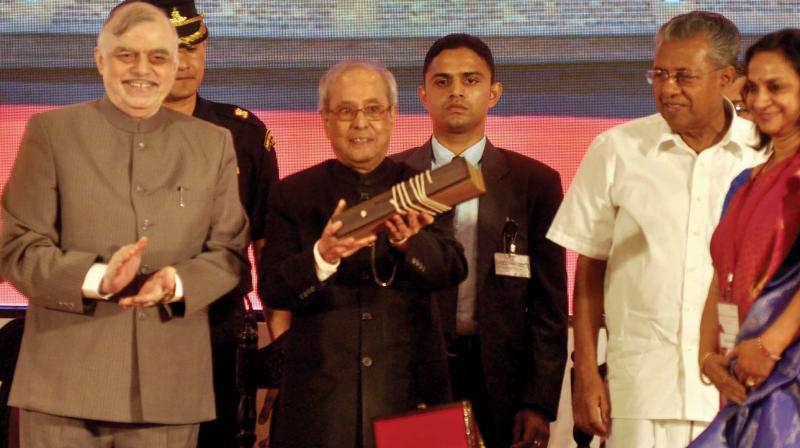 President Pranab Mukharjee accepts a copy of Ramayana written on palm leaves after delivering the 6th K.S Rajamony memorial lecture in Kochi on Thursday. Governor P.Sathasivam and Chief Minister Pinarayi Vijayan are also seen. (Photo: SUNOJ NINAN MATHEW)