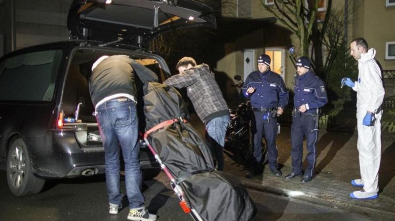 Undertakers lift a stretcher with a bodybag into a hearse in Herne, Germany. (AP Photo)