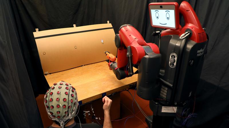 A system developed at MIT allows a human supervisor to correct a robots mistakes using gestures and brainwaves. (Photo: MIT CSAIL)