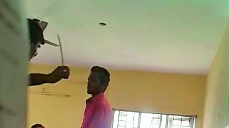 A videograb shows lecturer Dora Babu caning a student, another is made to sit on the floor.