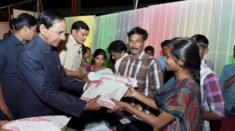 Telangana Chief Minister K Chandrasekhar Rao distributing clothes to differently able persons at the dinner hosted by him for the Christian community in Hyderabad. (Photo: PTI)