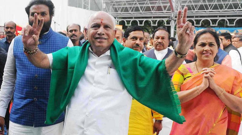 BJP leader B. S. Yeddyurappa flashes the victory sign as he arrives at Raj Bhavan to take oath as CM. (Photo:DC)