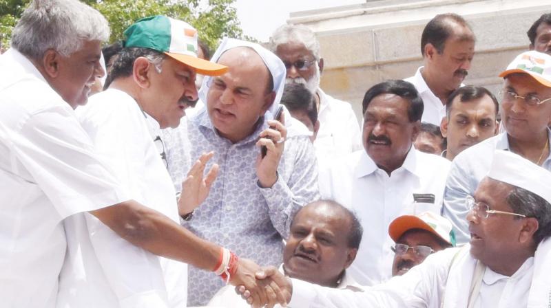 JD(S) MLA H.D. Revanna shakes hands with former chief minister Siddaramaiah as JD(S) state president H.D. Kumaraswamy and Congress MLA D.K. Shivakumar look on. (Photo:DC)