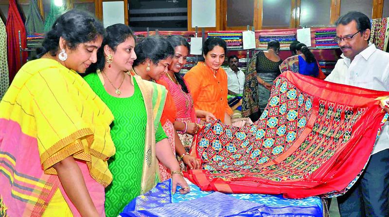 Women watch the saris at the Pochampally Ikat art mela at Patamata in Vijayawada on Friday. (Photo: DC)