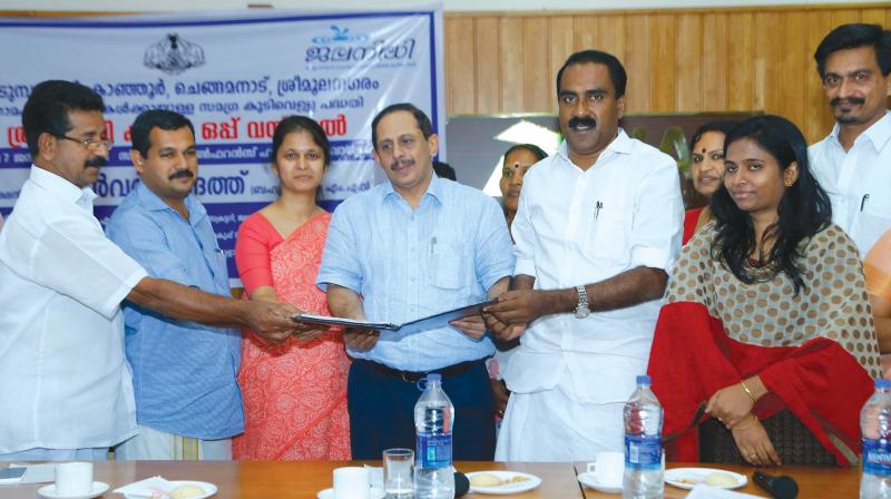 Jalanidhi executive director Tinku Biswal exchanges  the agreement for the drinking water project to panchayat presidents in the presence of CIAL managing director V.J. Kurien and Anwar Sadath, MLA.