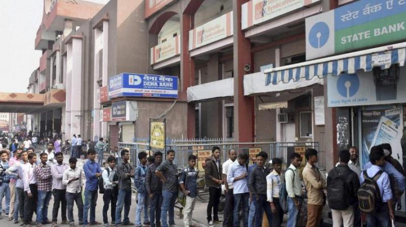 People stand in a long queue to withdraw money at an ATM. (Photo: PTI)