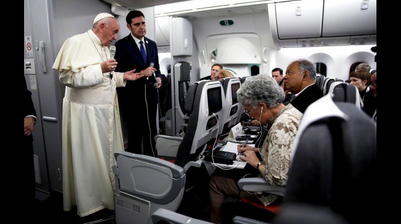 Pope Francis, with Vatican spokesman Alessandro Gisotti, answers reporters questions aboard the plane after taking off from Panama City. (Photo: AP)