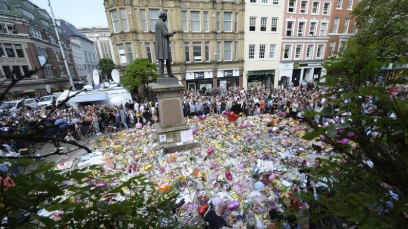 People hold a minute of silence in a square in central Manchester (Photo: AP)