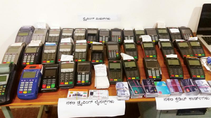 POS machines and cards the police found in the apartment of the accussed in Jalahalli 	(Photo:DC)