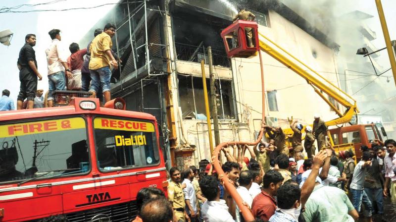 Firemen fight the blaze at a readymade unit at SM Street in Kozhikode. (Inset) Ill-maintained fire safety system at a shop at SM Street.