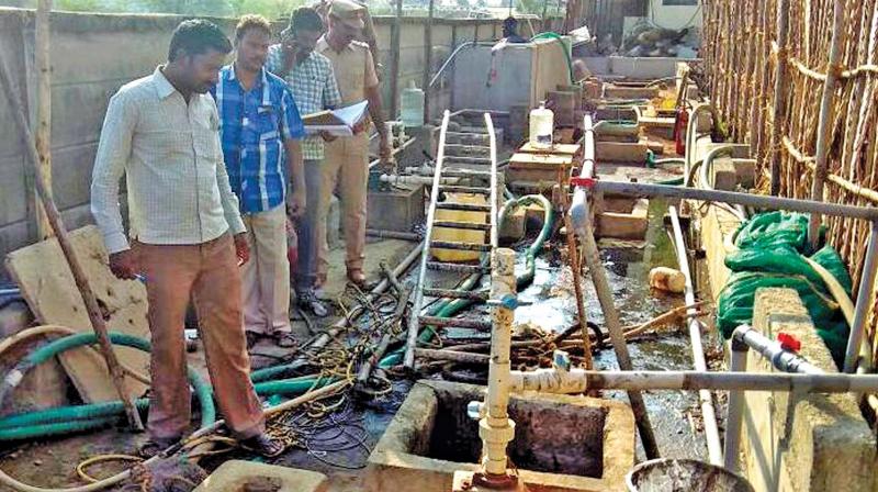 Police officers inspect the sewer tank in which  Murugesan, Maari and Ravi died. (Photo: DC0