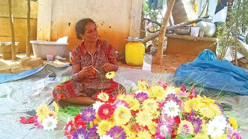A Narikuravar woman at Adigathur beads the flowers to make a vase