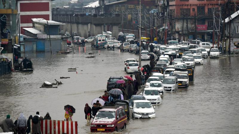Vehicles make way through a waterlogged street following heavy rains in Srinagar (Photo: PTI)