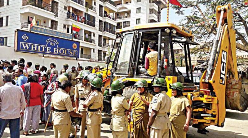 BBMP workers mark encroachments in the premises of White House apartment on Dinnur Main Road at RT Nagar, in Bengaluru on Thursday. (Photo: DC)