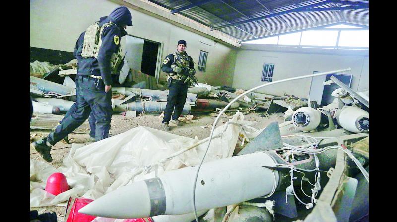 An Iraqi soldier inspects missiles found in a warehouse in the eastern side of Mosul, Iraq. (Photo: AP)
