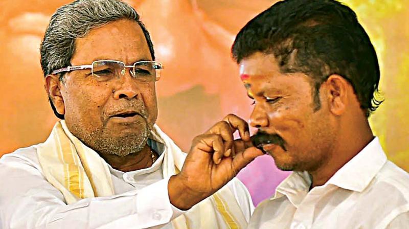 Chief Minister Siddaramaiah at a function held to distribute food and forest right certificates to tribals, in Mysore on Wednesday.