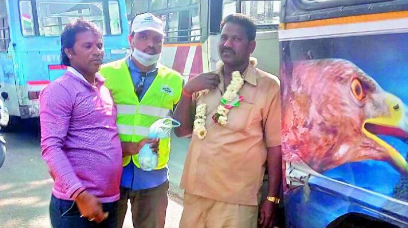 GHMC sanitation wing officers garland an RTC driver who was caught urinating in the open at Mehdipatnam. (Photo: DC)