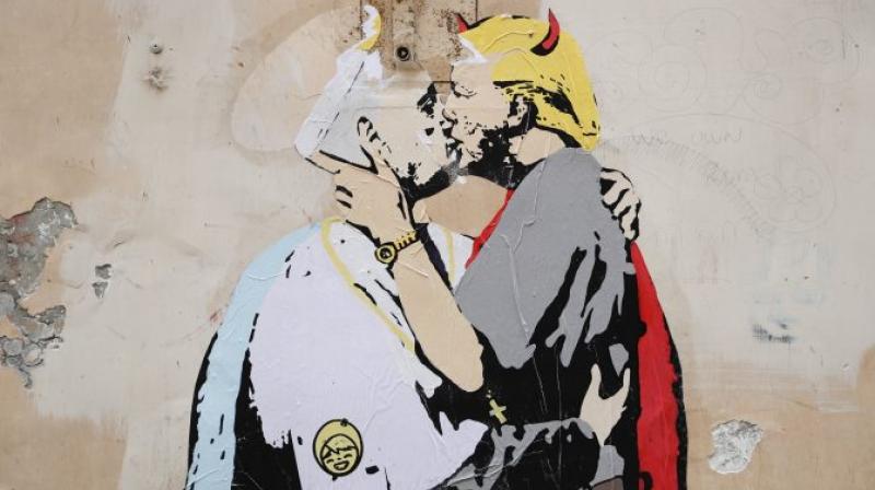 A mural signed by TV Boy and depicting Pope Francis and U.S. President Donald Trump kissing, is seen on a wall in downtown Rome. (Photo: AP)