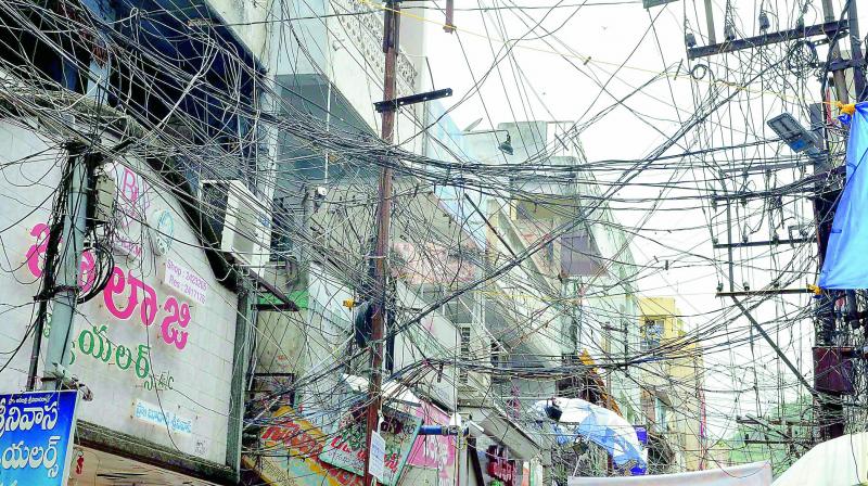 A mesh of power and other cables entangled at One Town Sivalayam Steet in Vijayawada. This is a common phenomenon in many poarts of the city. (Photo: DC)