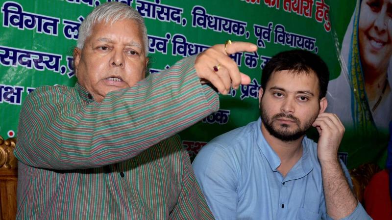 RJD Chief Lalu Prasad addressing a press conference with his son and deputy CM Tejashwi Yadav at his residence in Patna on Friday after CBI raids at his premises. (Photo: PTI)