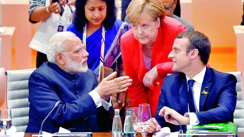 Prime Minister Narendra Modi with German Chancellor Angela Merkel and French President Emmanuel Macron at the G-20 Summit in Hamburg on Friday. (Photo: PTI)