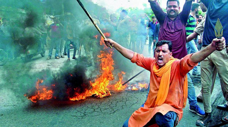Activists of Bajrang Dal burning the tyres and blocking a road following a bandh call in response against the attack on pilgrims, in Jammu on Tuesday.
