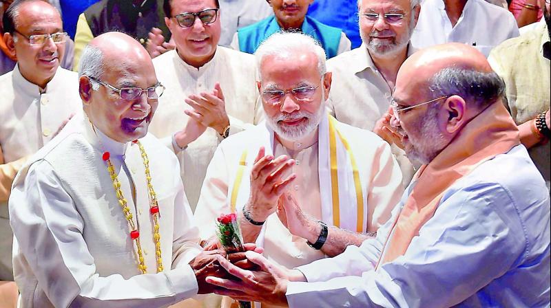Presidential candidate Ram Nath Kovind is greeted by BJP chief Amit Shah as Prime Minister Narendra Modi looks on at an NDA meeting in New Delhi on Sunday. (Photo: PTI)