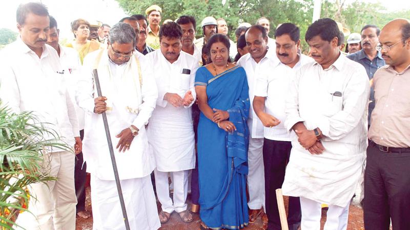 A file photo of Chief Minister Siddaramaiah, his son Dr Yathindra, and minister Dr H.C. Mahadevappa at the launch of a project in Chamarajanagar.