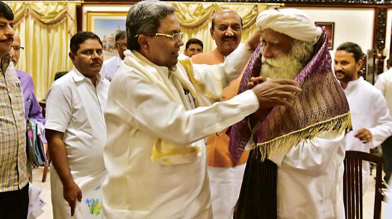 CM Siddaramaiah felicitates Sadguru Jaggi Vasudev at Vidhana Soudha on Monday. (Photo: DC)