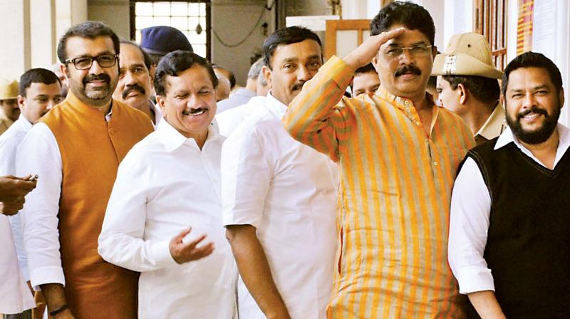 Legislators N.A. Haris of the Congress, and K.G. Bopaiah and R. Ashok of the BJP wait in a queue to cast their votes in Bengaluru on Monday. (Photo: DC)