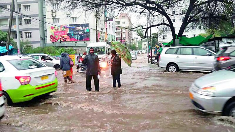 Commuters make their way across a flooded road in the city.