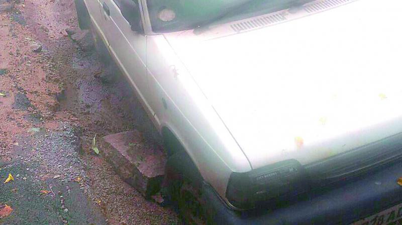 The Maruti 800 car stuck in a trench dug up by L&T in Sainikpuri limits.