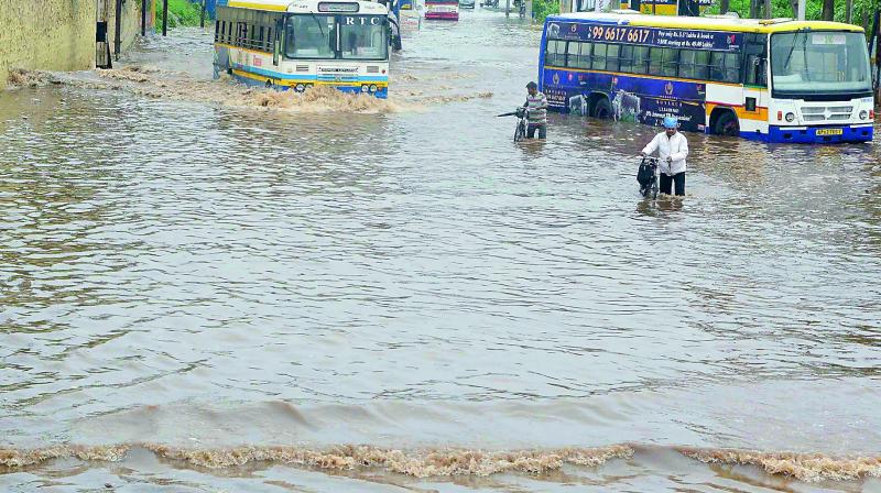 Low bridge between Rajiv Gandhi Park and new bus-stand on Krishnalanka highway waterlogged in Vijayawada on Tuesday. (Photo: DC)