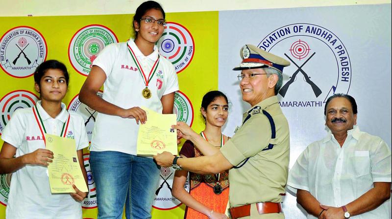 Commissioner of police D. Gautam Sawang presents prizes to rifle-shooters at a hotel in Vijayawada on Sunday. Narasapuram MP Gokaraju Gangaraju is also seen.