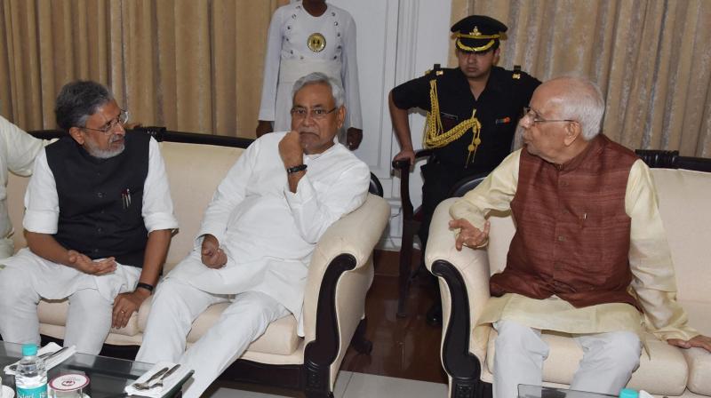 Bihar governor Keshri Nath Tripathi with Chief Minister Nitish Kumar and Deputy Chief Minister Sushil Kumar Modi during swearing-in ceremony of Ministers in Bihar cabinet at Raj Bhawan in Patna on Saturday. (Photo: PTI)