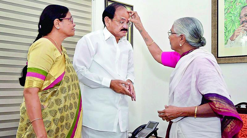 Kaushalya Maa, sister of Venkaiah Naidu, puts a tilak on his forehead as his wife Usha looks on after Venkaiah was elected as the Vice-President, in New Delhi on Saturday. (Photo: PTI)