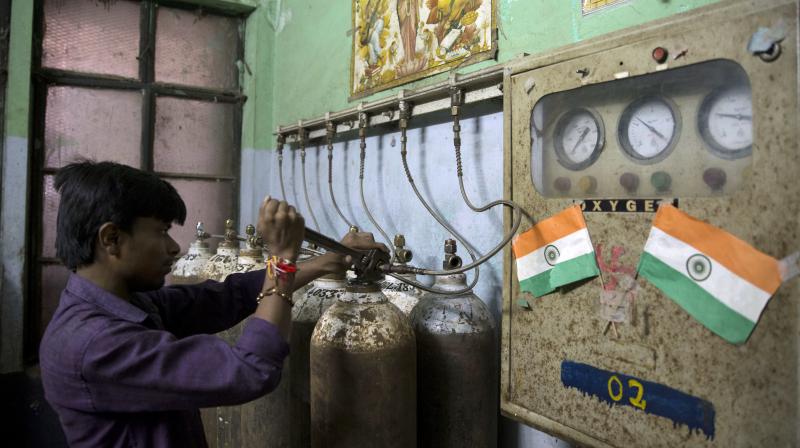A hospital staff member checks newly arrived oxygen cylinders at Baba Raghav Das Medical College Hospital in Gorakhpur, in the northern Indian state of Uttar Pradesh. (Photo: AP)