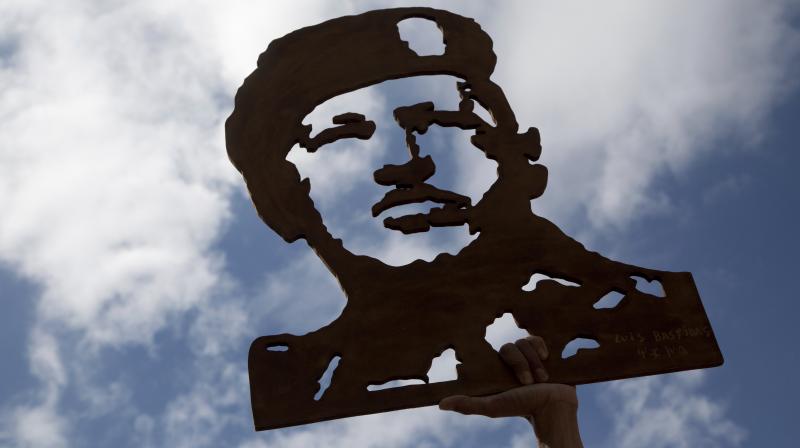 A image of late Venezuelas President Hugo Chavez is raised by a supporters of Venezuelas President Nicolas Maduro as they prepare for a march to the National Assembly for the swearing in ceremony of the Constituent Assembly in Caracas. (Photo: AP)