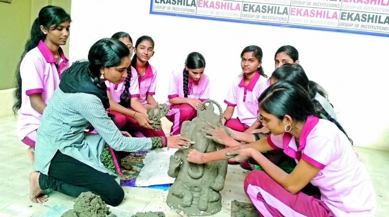 A group of students give final touches to the Ganesh idol they made in Warangal on Friday. (Photo: DC)