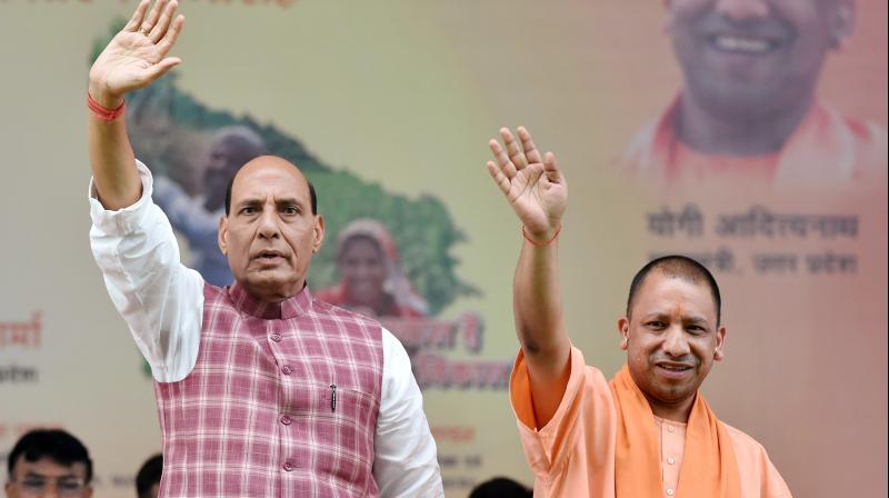 Union Home Minister Rajnath Singh with Uttar Pradesh Chief Minister Yogi Adityanath waves during a function to distribute loan waiver certificates to farmers under Fasli Rin Mochan Yojna in Lucknow on Thursday. (Photo: PTI)