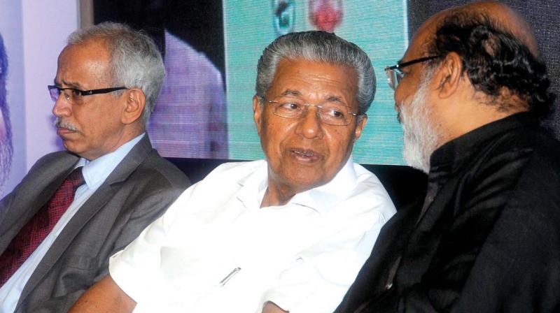 Chief Minister Pinarayi Vijayan chats with finance minister Thomas Isaac during the inauguration of the seminar on opportunities and challenges in public infrastructure financing in Thiruvannathapuram on Saturday. SEBI board member G. Mahalingam is also seen. (Photo: A.V. MUZAFAR)