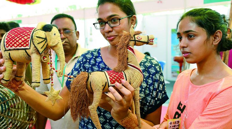 Girls take a look the toys made from coconut fibre at a toys exhibition arranged on World Coconut Day in Vijayawada,  on Saturday. (Photo: DC)