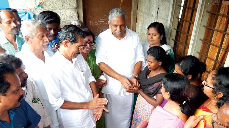Minister AC Moideen handing over the key of their house attached by bank to the Dalit family on Sunday. (Photo: DC)