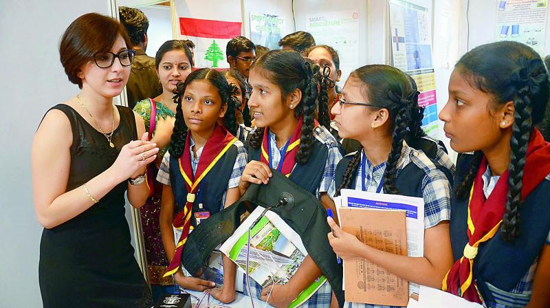 A delegate from Poland explains about a product to the schoolchildren at the International Innovation Fair in Visakhapatnam on Saturday. (Photo: DC)